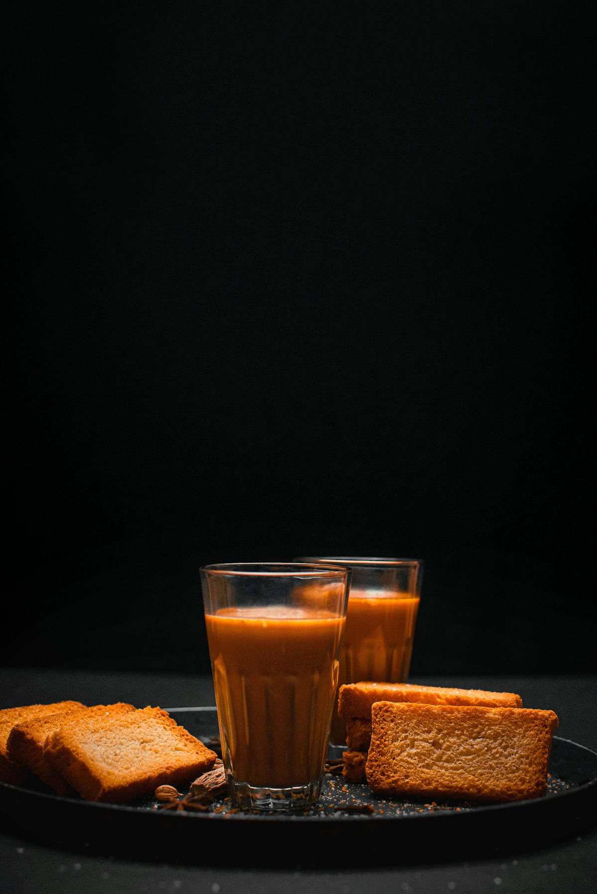 Glasses of golden chai with rusk