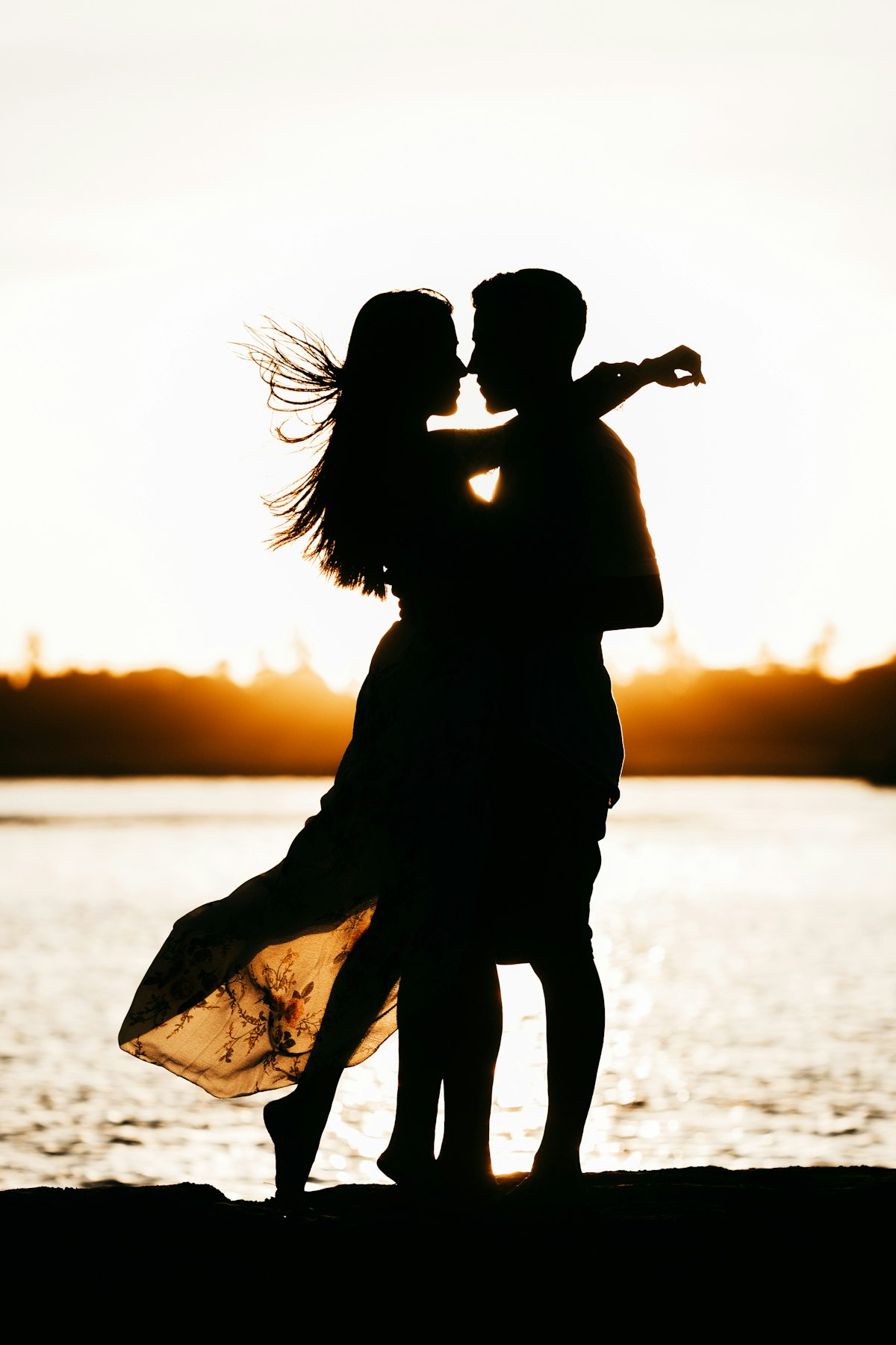 Backlit couple at the lakeshore
