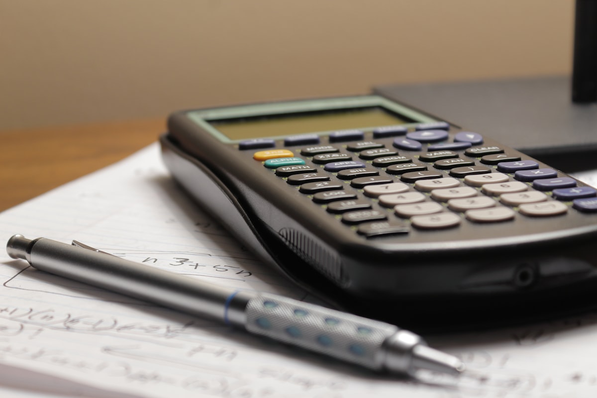 Math homework with a calculator and pen