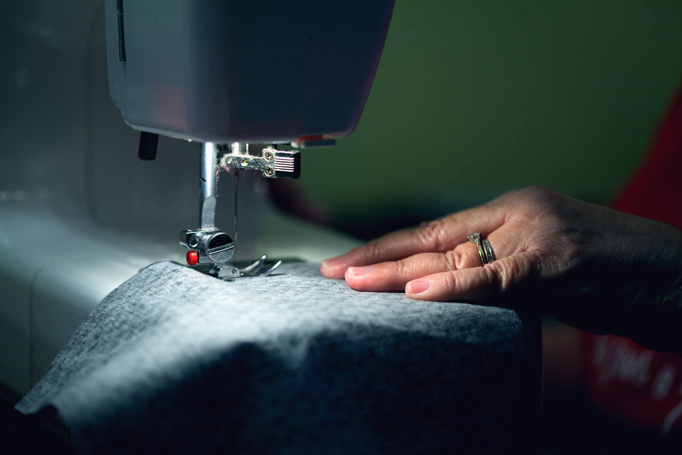 Hands guiding fabric through a sewing machine