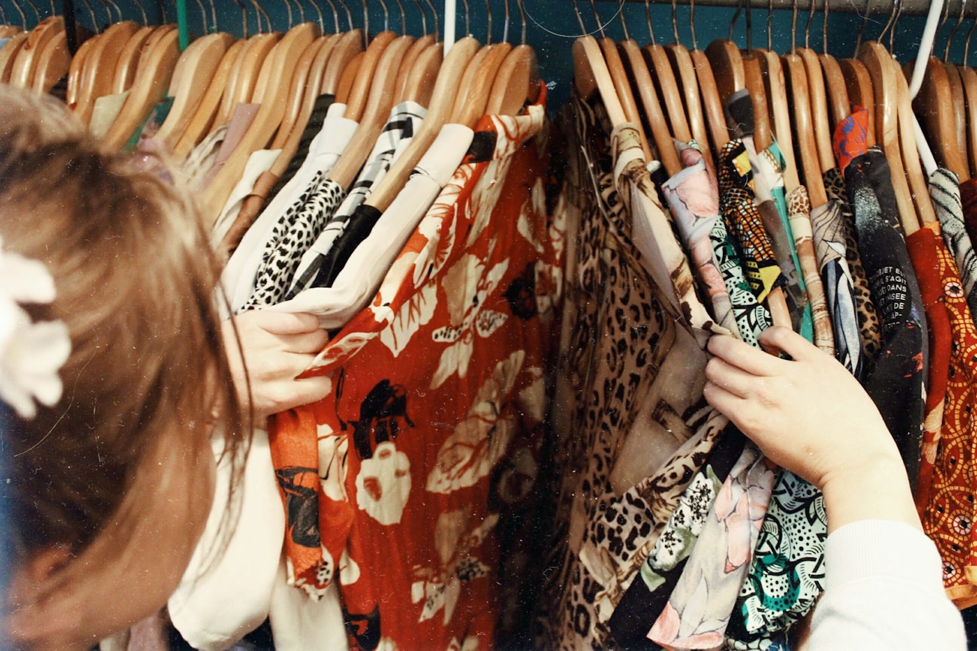 Browsing patterned shirts on a thrift store rack