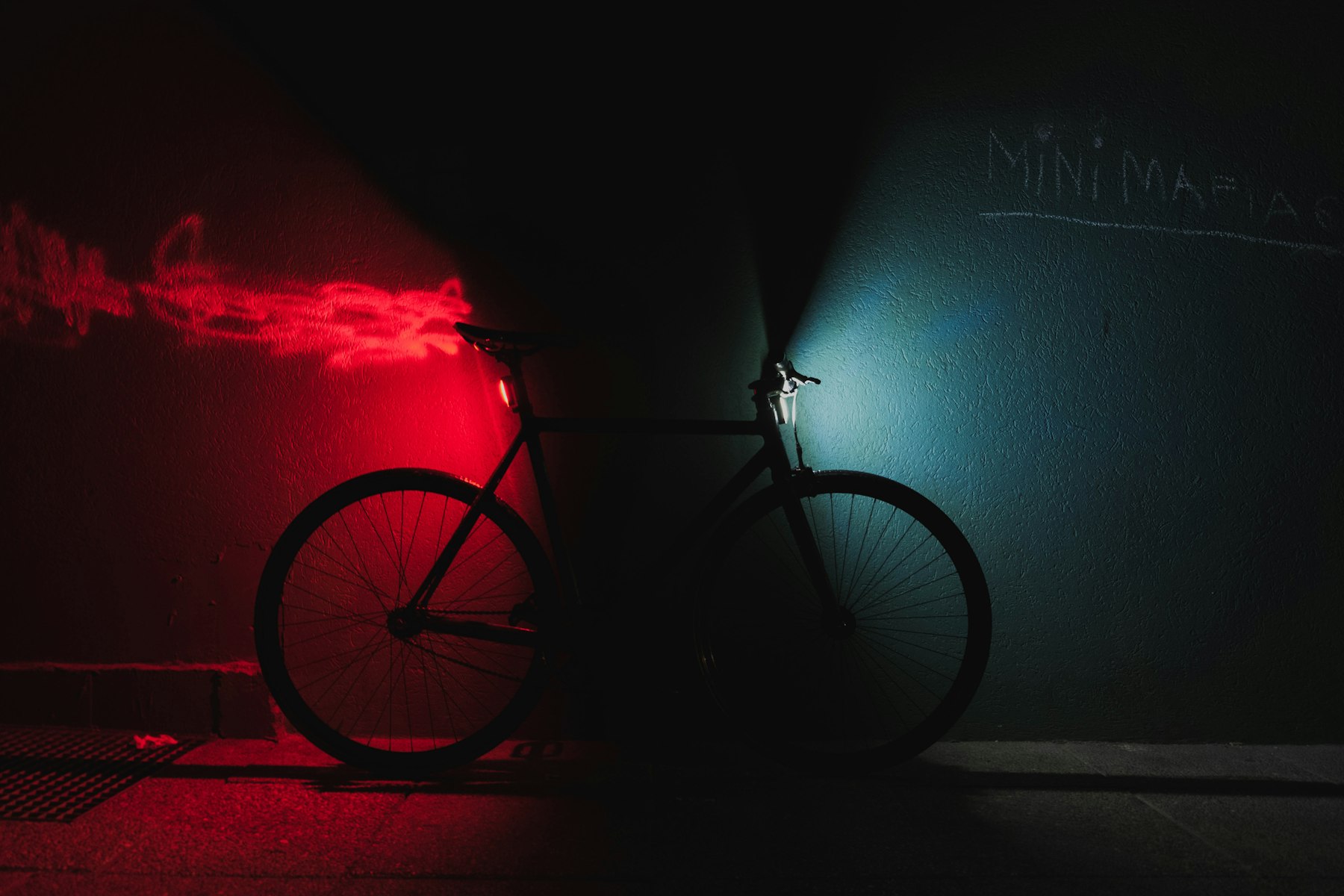 Bike leaning on a wall at night with front and rear lights on