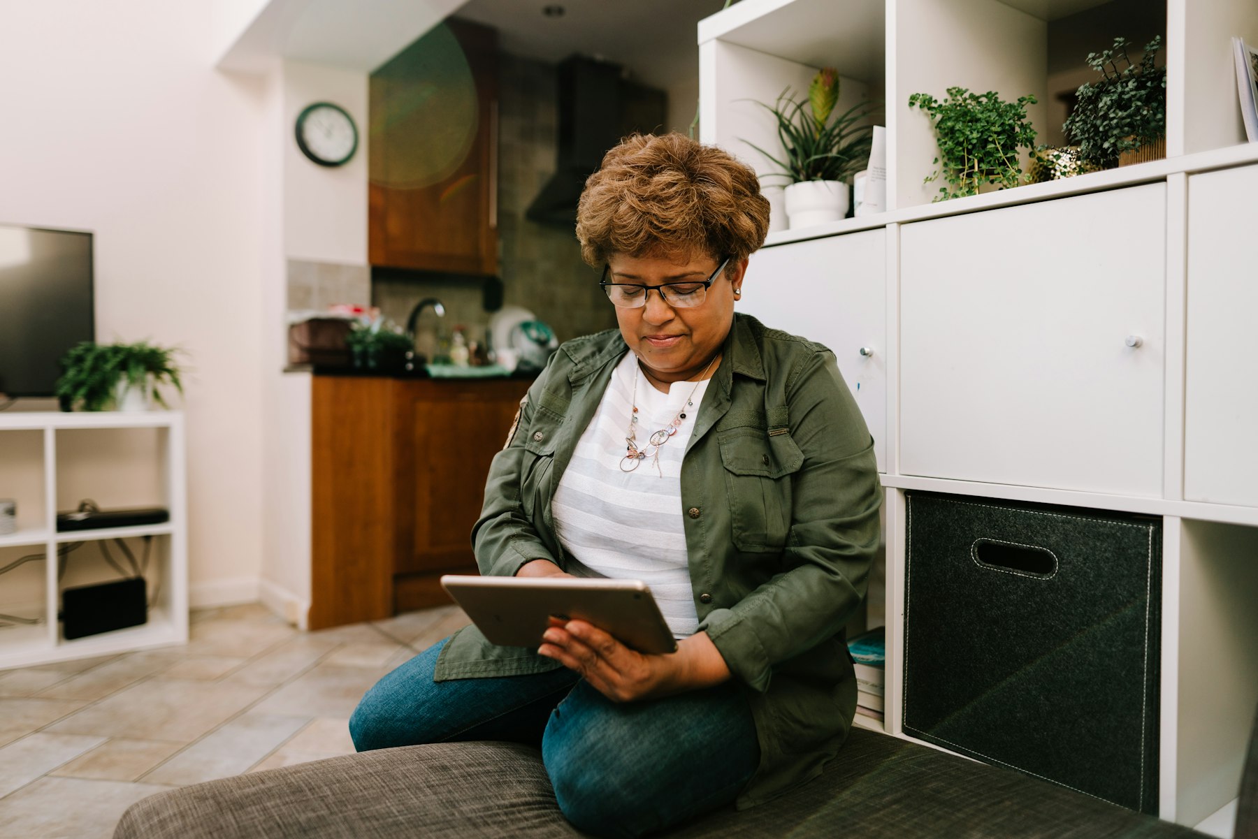 A senior woman using her tablet at home