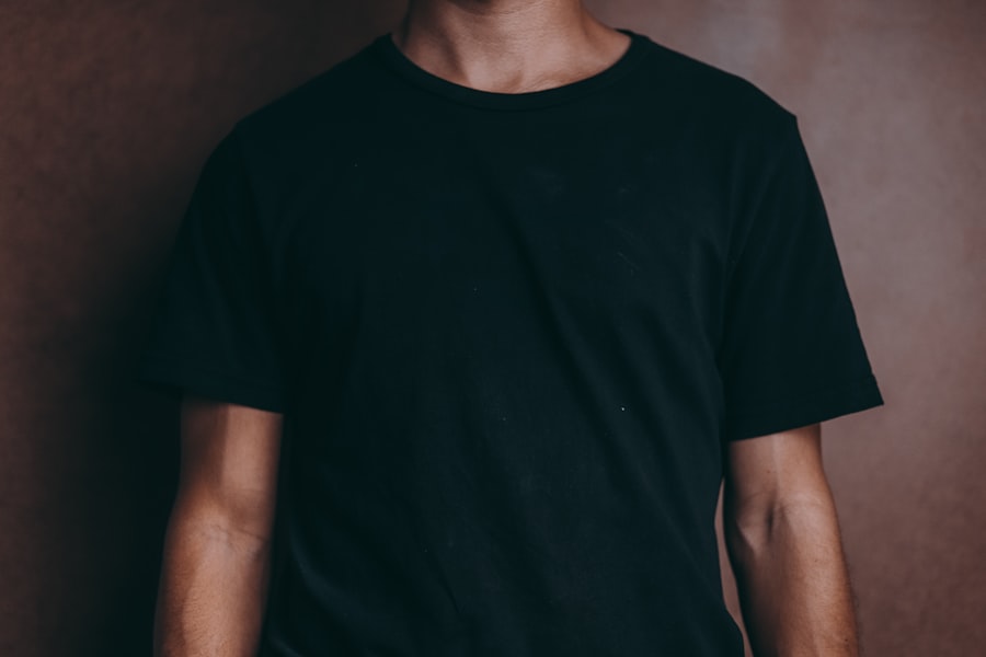 A person wearing a plain black tee shirt
