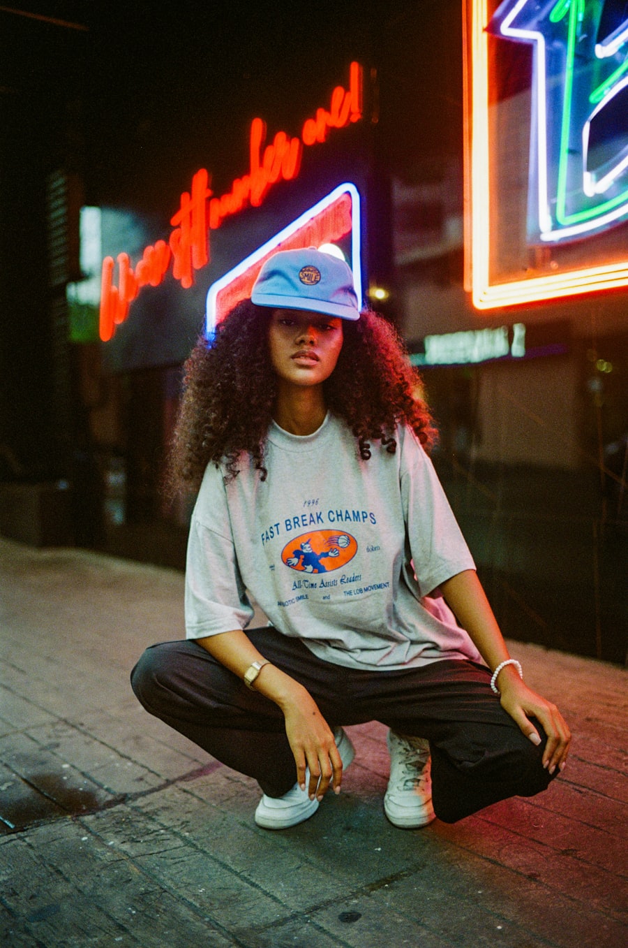 A person in a printed tee shirt in front of neon signs
