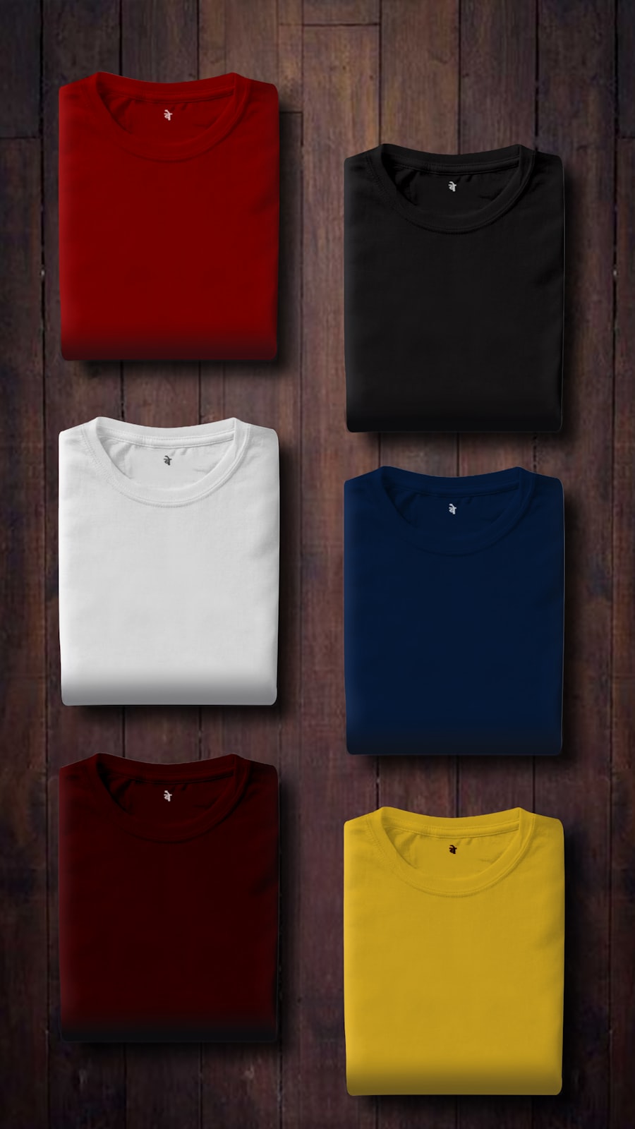 Folded tee shirts arranged in a grid on wood