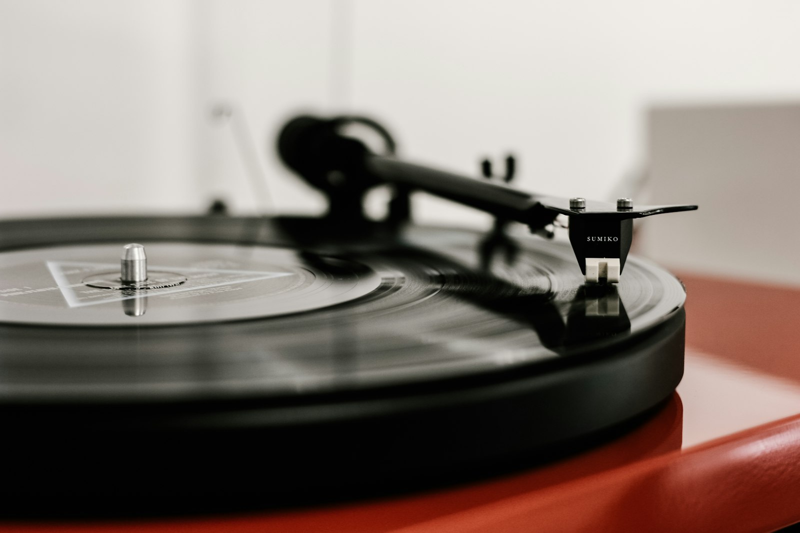 A tonearm resting on a record on a dark turntable
