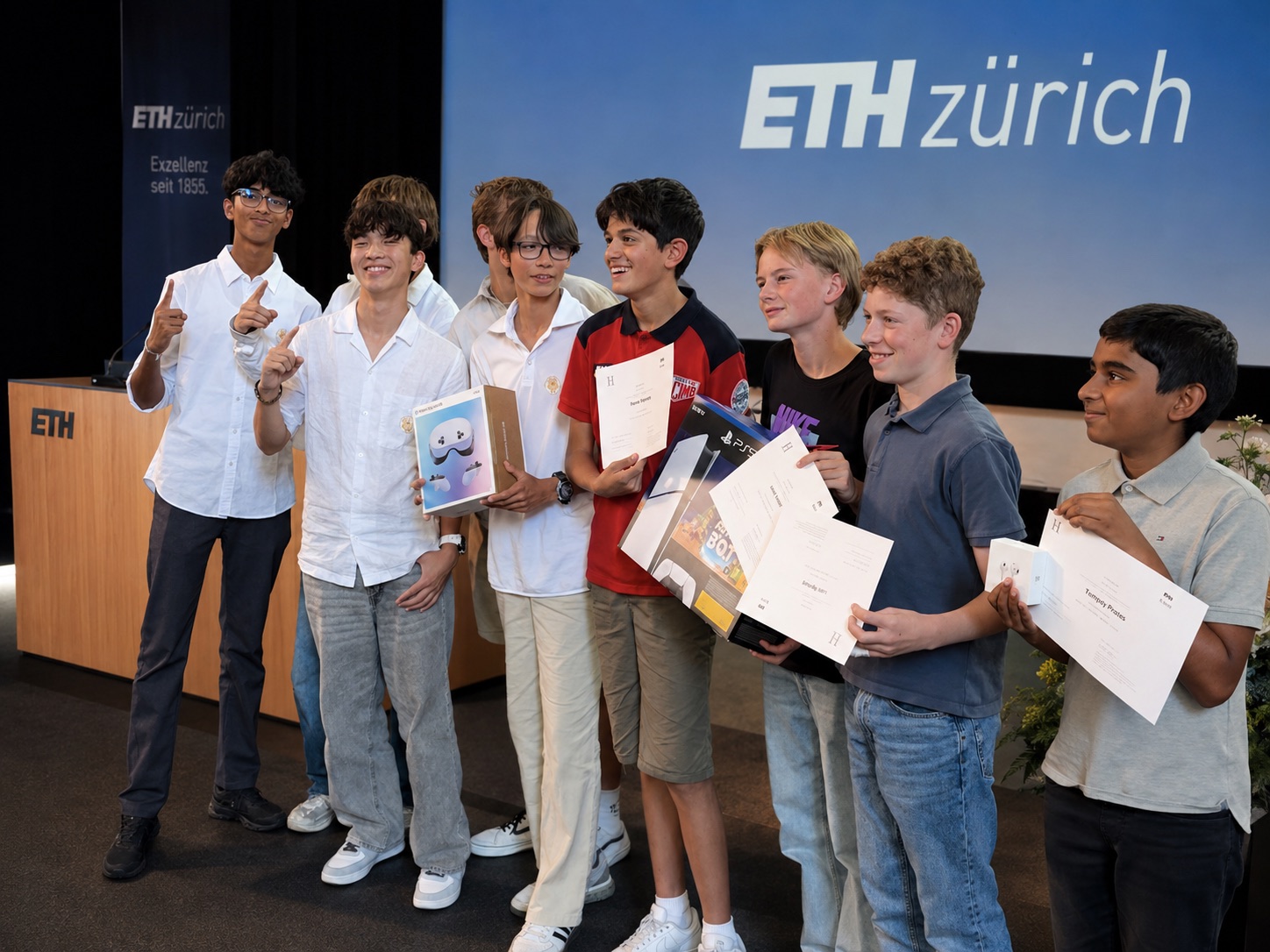 Students holding their prizes and certificates on stage at our summer programme at ETH Zurich